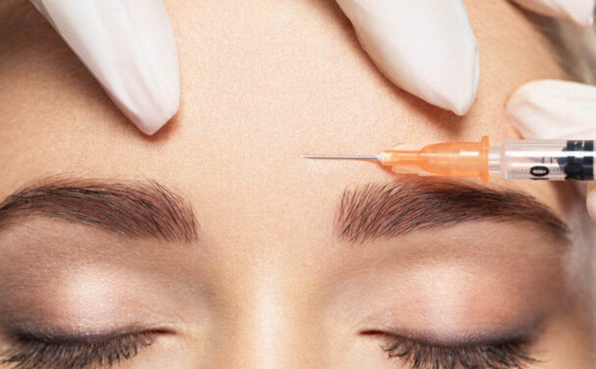 Woman getting cosmetic injection of botox near eyes
