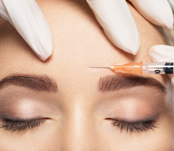 Woman getting cosmetic injection of botox near eyes